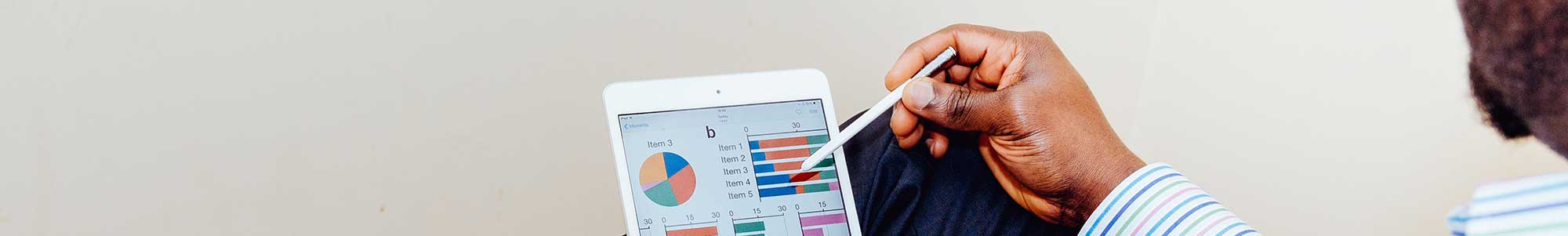 Afbeelding van een man die met een stylus op een tablet grafieken bekijkt en aanklikt