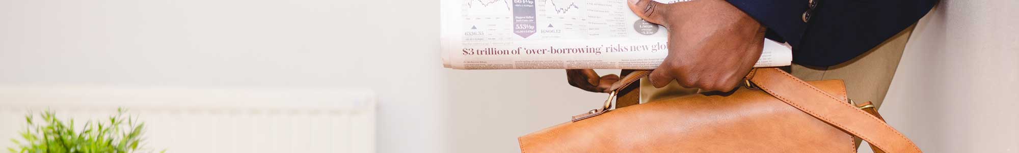 Afbeelding van man die een aktetas met krant vasthoudt