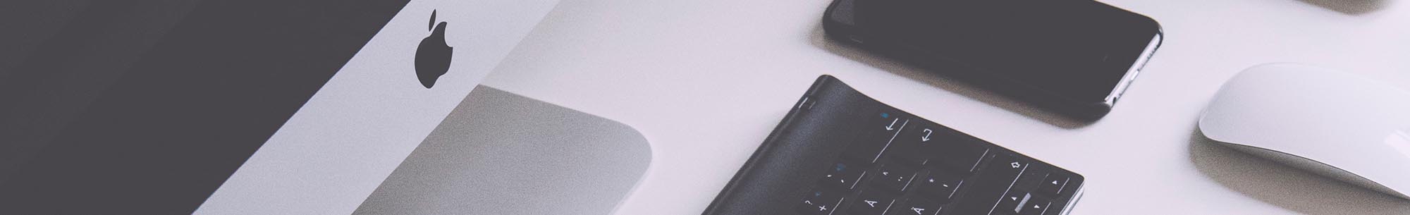 Deel afbeelding van een iMac en iPhone op een bureau